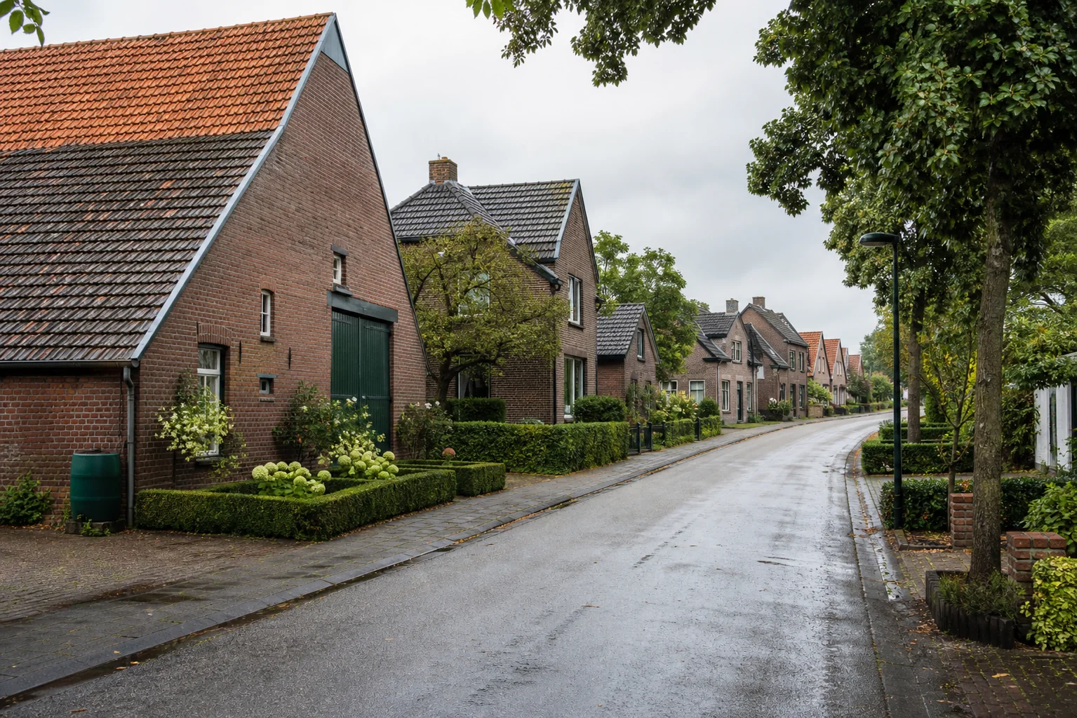 Groene dorpsstraat met bakstenen huizen en pannendaken